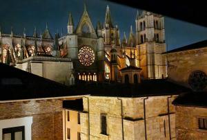 een groot gebouw met een kasteel op de achtergrond bij Hotel Spa QH Centro León in León