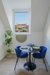 Una mesa y sillas en una habitación con ventana. en City Mini Studio, en Bratislava