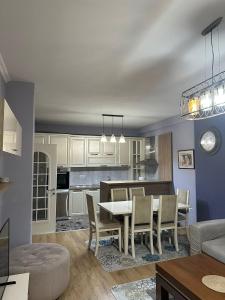una cucina e un soggiorno con tavolo e sedie di Modern 2BR Apartment with Living Room and Private garage a Kashari