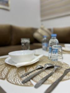 a table with a plate and a bowl and utensils at Studio lumineux avec terrasse in Er Rachidia