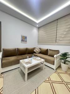 a living room with a couch and a table at Studio lumineux avec terrasse in Er Rachidia +1 photo