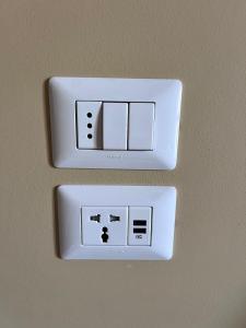 a white lightswitch on a wall in a room at La Ginestra in Santa Maria degli Angeli