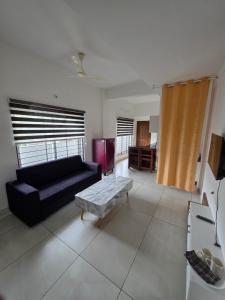a living room with a black couch and a coffee table at Atharva homes at Vallikavu Amritapuri in Perinād