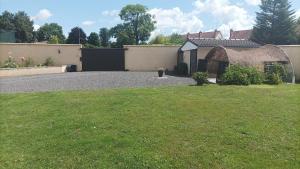 a house with a grass yard with a building at Maison Le Nova in Paray-le-Monial
