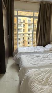 a bedroom with two beds and a large window at مجمع زهرة الخريف in Salalah