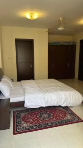a large bed in a bedroom with a rug on the floor at مجمع زهرة الخريف in Salalah +2 photos