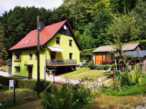 a yellow house with a red roof at Ferienhaus am Röhrensteig in Bad Gottleuba
