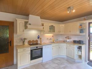 a kitchen with white appliances and a wooden ceiling at Ferienhaus am Röhrensteig in Bad Gottleuba
