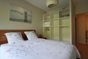 a bedroom with a white bed with red flowers on it at A4 - Résidence La Montille in Mont-Dore