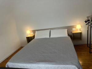 a bed in a room with two lamps on both sides at Miralong House in Catania
