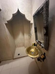 uma casa de banho com um lavatório dourado e um espelho em Riad Salma Restaurant Spa em Marraquexe mais 37 fotografias
