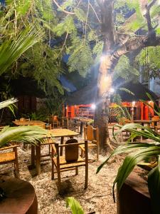 a patio with a table and chairs and a tree at Kimulimuli Ayurveda Spa Retreat in Kiganga