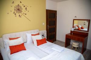 a bedroom with a white bed with orange pillows and a mirror at Apartamenty Every Sky Polna 4 Karpacz in Karpacz