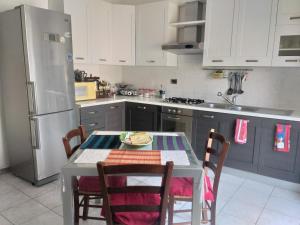 a kitchen with a table with chairs and a refrigerator at Casa Nicoletta Apartment in Ravenna