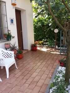 a patio with a white bench and some plants at Casa Nicoletta Apartment in Ravenna