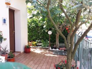 a porch with a tree and some flowers at Casa Nicoletta Apartment in Ravenna +1 photo