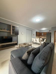 a living room with a blue couch and a table at 12valentina in Vlorë