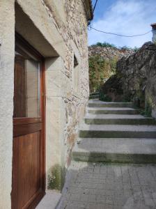a stone building with a wooden door and stairs at CasaManuela in Porto do Son +2 photos