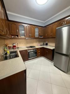 a kitchen with wooden cabinets and a stainless steel refrigerator at 12valentina in Vlorë