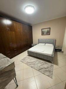 a bedroom with a bed and wooden cabinets at 12valentina in Vlorë