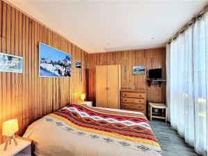 a bedroom with a bed and a television in it at Appartement rénové, accès direct pistes, piscine, animaux admis - FR-1-267-228 in Le Corbier +14 photos