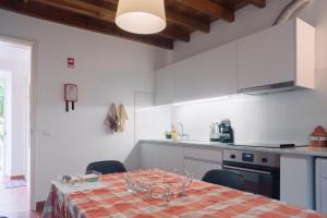 una cucina con un tavolo e sedie in una stanza di Apartamentos da Galé a Caloura