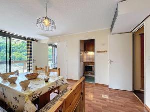 a kitchen with a table and a dining room at Confortable appartement skis aux pieds avec grand balcon - FR-1-267-210 in Villarembert