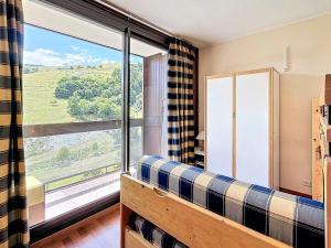 a living room with a couch and a large window at Confortable appartement skis aux pieds avec grand balcon - FR-1-267-210 in Villarembert