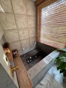 a shower with a tub in a room with a window at Treze Tílias Tiny House in Treze Tílias