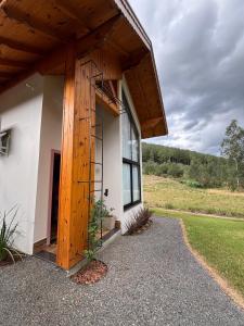a building with a large window and a wooden roof at Treze Tílias Tiny House in Treze Tílias