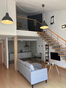 Una sala de estar con un sofá y una escalera. en Loft Almagro, en Almagro