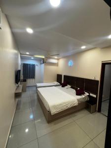 Un dormitorio con dos camas y un televisor. en Hotel SRI DEEPTHI LODGE, en Ādoni