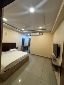 Un dormitorio con una cama y un televisor de pantalla plana. en Hotel SRI DEEPTHI LODGE, en Ādoni
