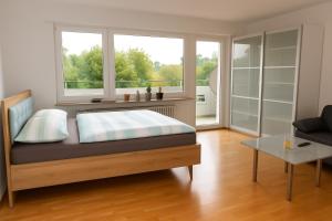 una camera da letto con un letto e una grande finestra di Ferienwohnung Bella Vista a Eimeldingen