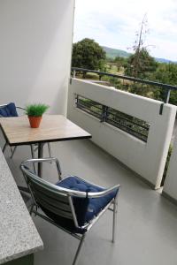 balcone con tavolo, sedia e tavolo di Ferienwohnung Bella Vista a Eimeldingen