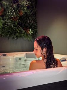 Una donna è seduta in una vasca da bagno di Hotel Garnì San Giorgio a Trento
