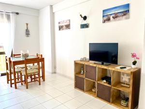 a living room with a television and a table at Casa da Praia II na Torre Baleeira in Armação de Pêra