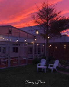 two white chairs sitting in a yard at sunset at SH Hotel & Spa de Mar Samay Huasi in Puerto Madryn