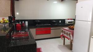 a kitchen with a black counter and a white refrigerator at Casa de temporada em Aruanã in Aruanã +1 photo