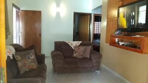a living room with two chairs and a television at Casa de temporada em Aruanã in Aruanã