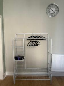 エディンバラにあるDouble room with garden In The Heart of Edinburghの壁に掛けられたグラスと時計のラック