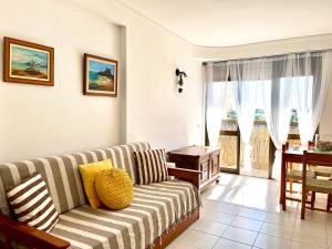a living room with a couch and a table at Casa da Praia II na Torre Baleeira in Armação de Pêra