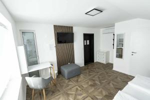 a white room with a television and a chair at Sleepoteca in Šentilj