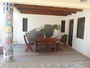 Una mesa y sillas de madera en un patio. en villa paradiso2 with private pool, en Pitsidia