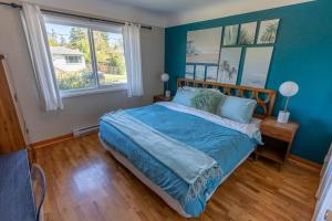 a blue bedroom with a bed and a window at Mid-Century Modern Apartment at Horner Park in Victoria