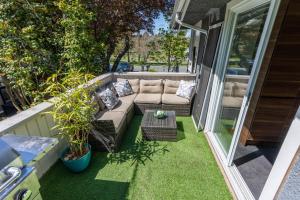 a small patio with a couch on a balcony at Mid-Century Modern Apartment at Horner Park in Victoria +11 photos