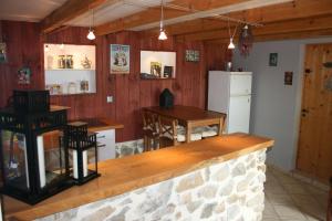 una cucina con pareti in legno e bancone con tavolo di La Maison dans les Nuages a Sécheras