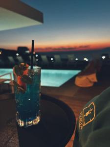 a drink sitting on a table next to a pool at Hotel Porta Ksamil in Ksamil