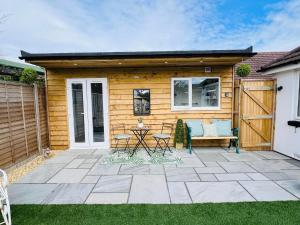 a patio with a couch and a table at Mudeford Gem Accommdation in Christchurch