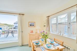 a dining room with a table and chairs and a window at Easter, Folly Lane, Salcombe in Salcombe +31 photos